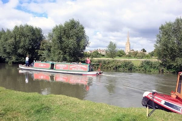 Lechlade. A canal boat on the upper Thames near St Lawrences Church at