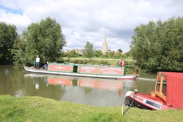 Lechlade. A canal boat on the upper Thames near St Lawrences Church at