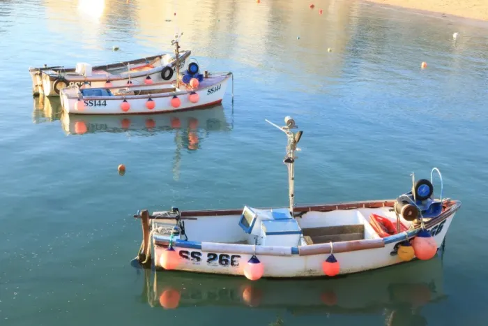 Framed Print : St Ives. Colourful fenders on the side of little open Fishing Boats lit Framed Print : St Ives. Colourful fenders on the side of little open Fishing Boats lit