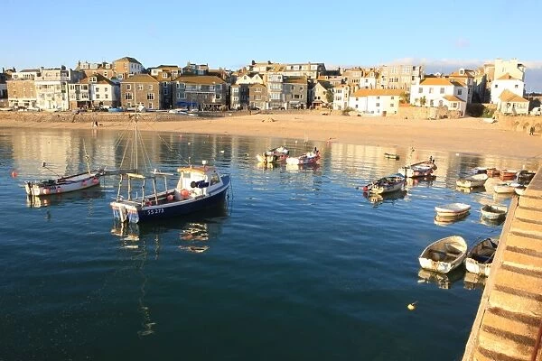 St Ives. Colourful little open Fishing Boats lit by pale afternoon sun light
