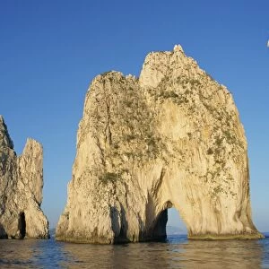Rock arches known as the Faraglioni Stacks off the