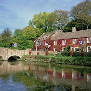 The Swan Hotel reflected in the river at Bibury in the Cotswolds, Gloucestershire