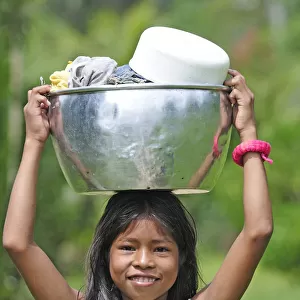 Young girl with a bucket on her head, Amacayon Indian Village, Amazon river, Puerto