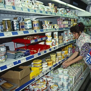 Holland, Supermarket interior with woman and young girl placing food items into trolley