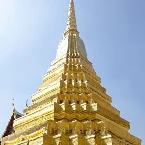 Bangkok, Thailand - Golden statues are holding a golden tiered building over their head