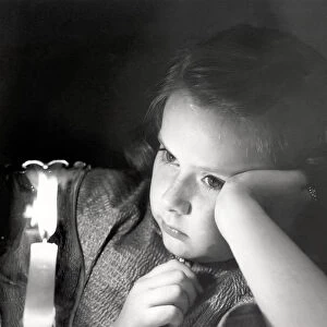 Girl looking at lighted candle