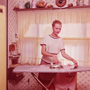 Woman ironing clothes in 1970s home