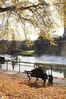 <b class=qtipBold><figcaption>Lovers of Bath</figcaption></b><br>Two lovers on a sunny morning in early winter beside the River Avon in the City of Bath with the leaves around there park bench;<br><em>© Paul Felix Photography, Twelve Beacon Park, Pelynt near Looe Cornwall</em> Lovers of Bath